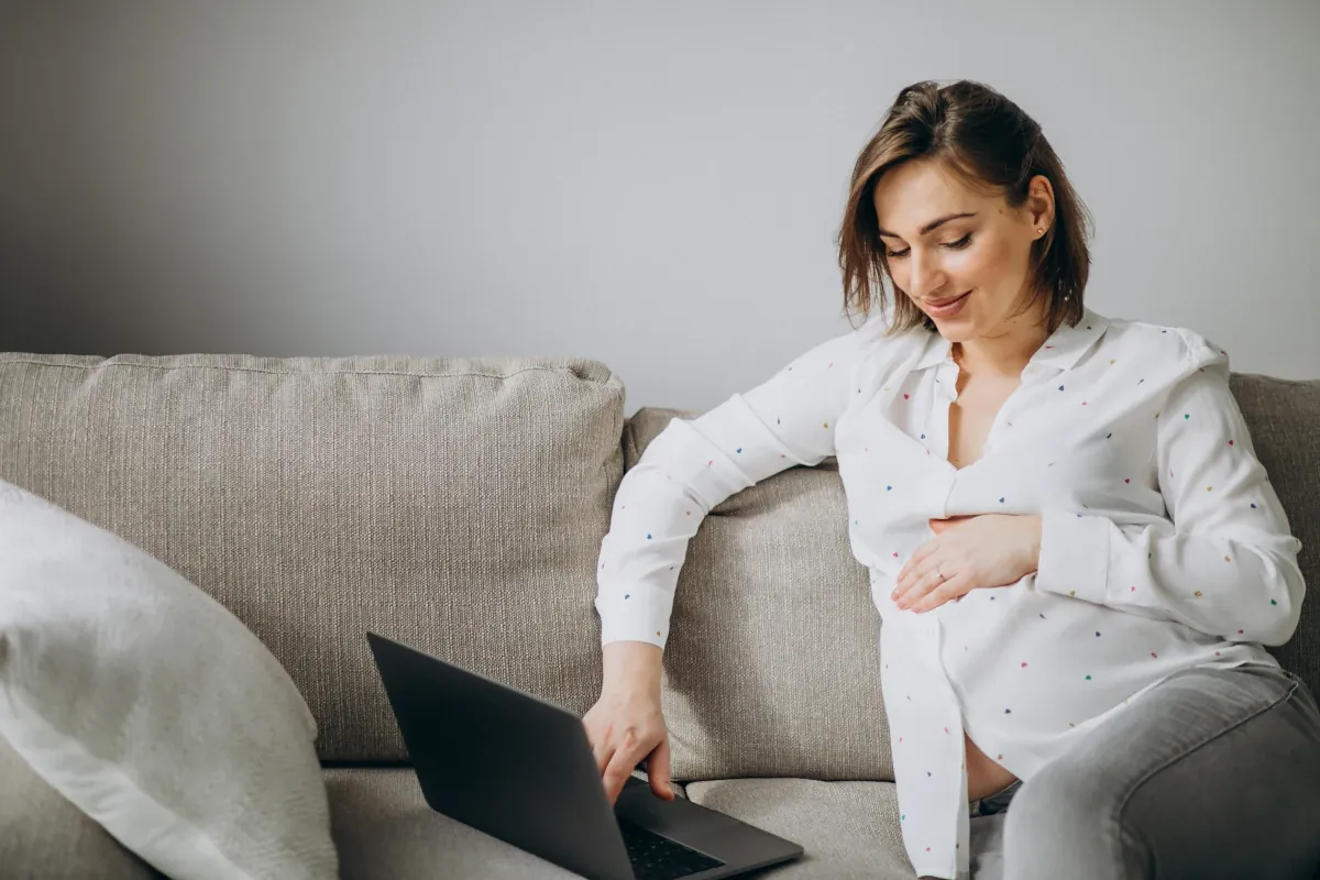 Zwangere vrouw volgt de online cursus op haar laptop